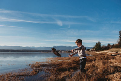 Full length of man standing on shore against sky