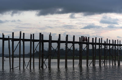 Pier over sea against sky during sunset