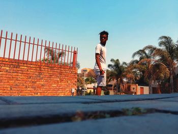 Young man standing against clear sky