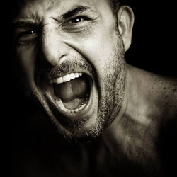 Portrait of young woman against black background
