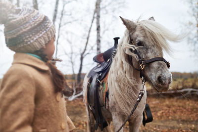 Unrecognizable girl with beautiful pony