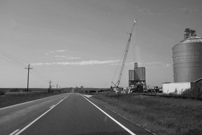 Road amidst field against sky