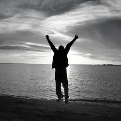 Silhouette of woman jumping on beach