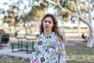 Portrait of young woman standing in park