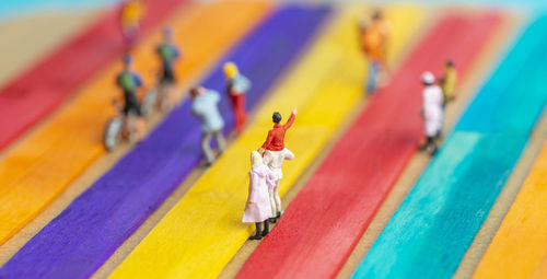 Close-up of human figurines on colorful table