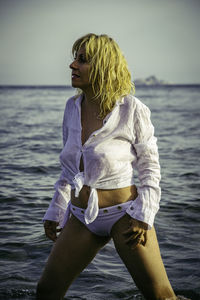 Woman wearing shirt standing in sea