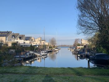 Scenic view of river by buildings against sky