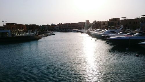 Boats in river with city in background