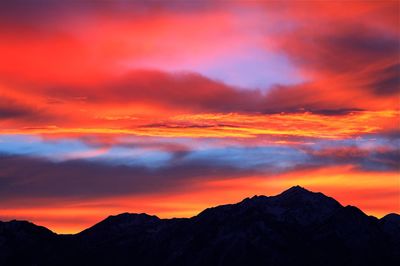 Scenic view of silhouette mountains against romantic sky at sunset