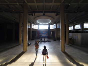 Rear view of woman walking in corridor