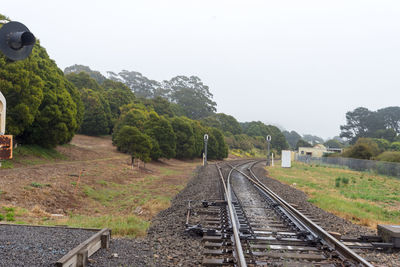 Railroad tracks amidst trees against clear sky