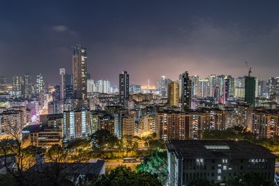 Illuminated cityscape against sky at night