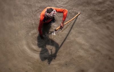 High angle view of man holding leaf in water