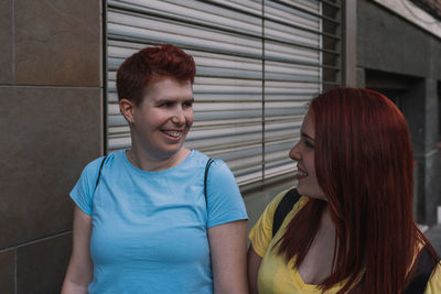 Happy lesbian couple walking on footpath