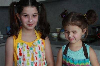 Portrait of smiling girls at the domestic kitchen at home