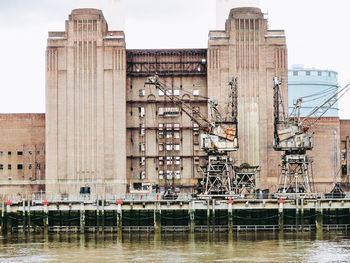 View of old building by river against sky