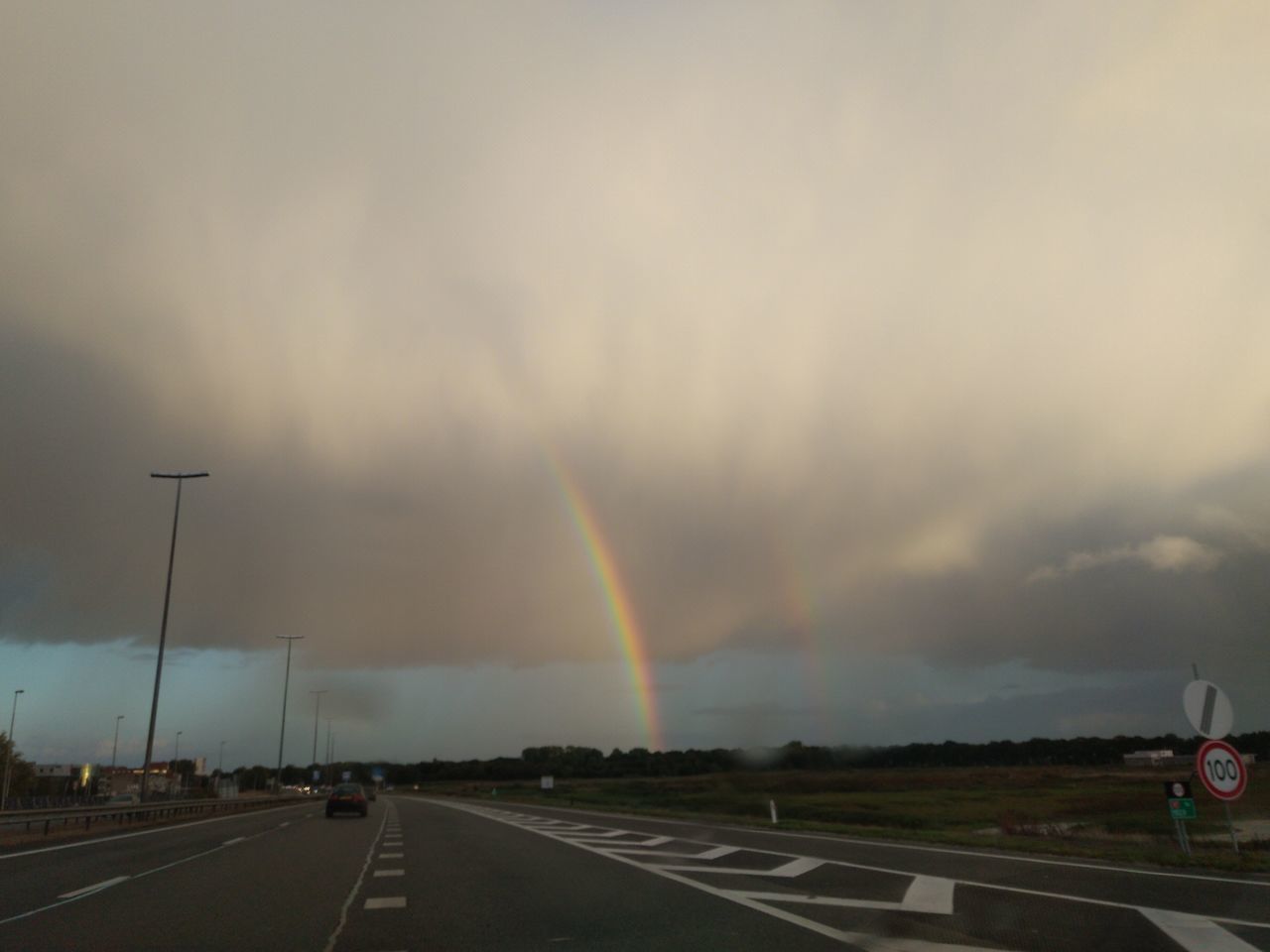 VIEW OF RAINBOW OVER ROAD AGAINST SKY