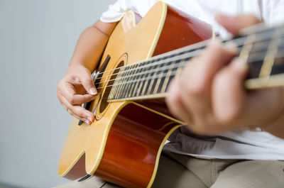 Midsection of woman playing guitar