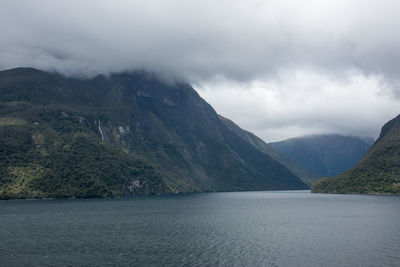 Scenic view of sea and mountains against sky