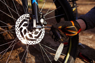 Close-up of man working on bicycle