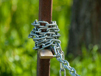 Close-up of chain tied up on metal pole