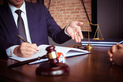 Midsection of man holding glass table