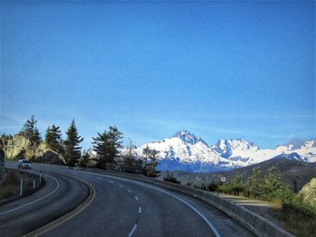 Road by mountains against clear blue sky