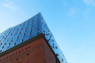 Low angle view of modern building against blue sky