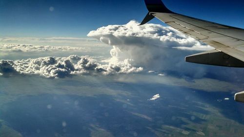 Cropped image of airplane flying over cloudscape