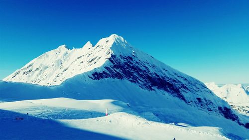 Scenic view of snow covered mountains against clear sky