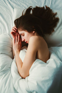 High angle view of woman sleeping on bed