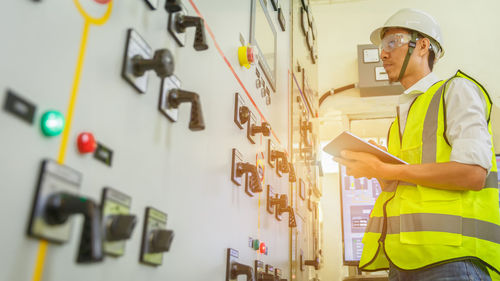  engineer working on the checking status switchgear electrical energy distribution substation.