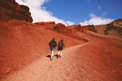 Rear view of people hiking at desert