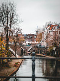 Canal amidst buildings in city against clear sky