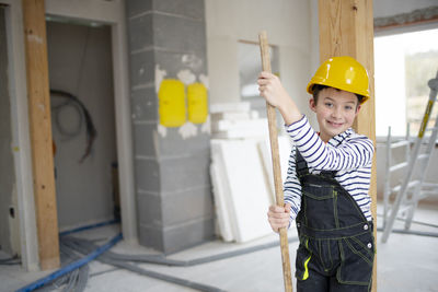 Portrait of young man standing against wall