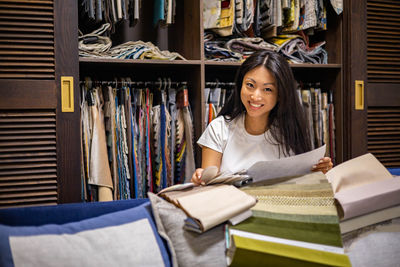 Young woman holding paper at office