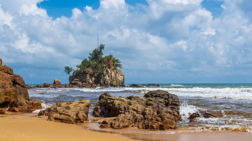 Rocks on beach against sky