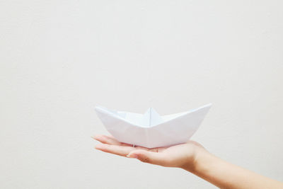 Midsection of person holding paper against white background
