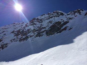 Scenic view of snowcapped mountains against sky on sunny day