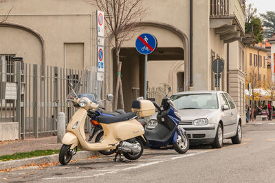 Motorcycle parked on street against buildings in city