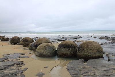 Rocks on beach against sky