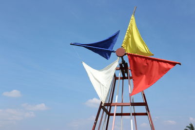 Low angle view of flags flag against blue sky
