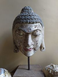 Close-up of buddha statue against wall