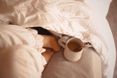 High angle view of coffee cup on bed