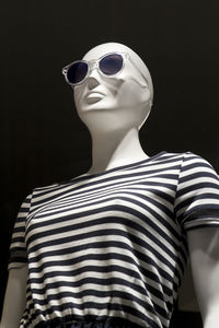 Low angle view of mannequin against black background
