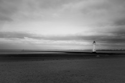 Lighthouse by sea against sky