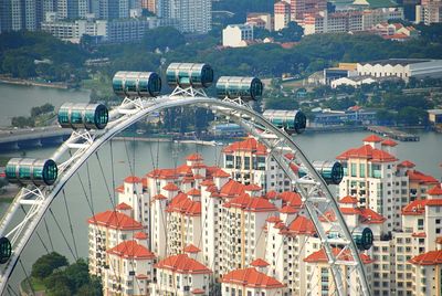 High angle view of ferris wheel in front of city buildings