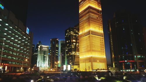 Low angle view of skyscrapers lit up at night