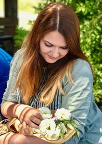 Smiling young woman holding flowers