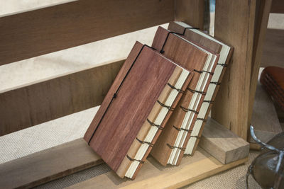 High angle view of books on wooden shelf